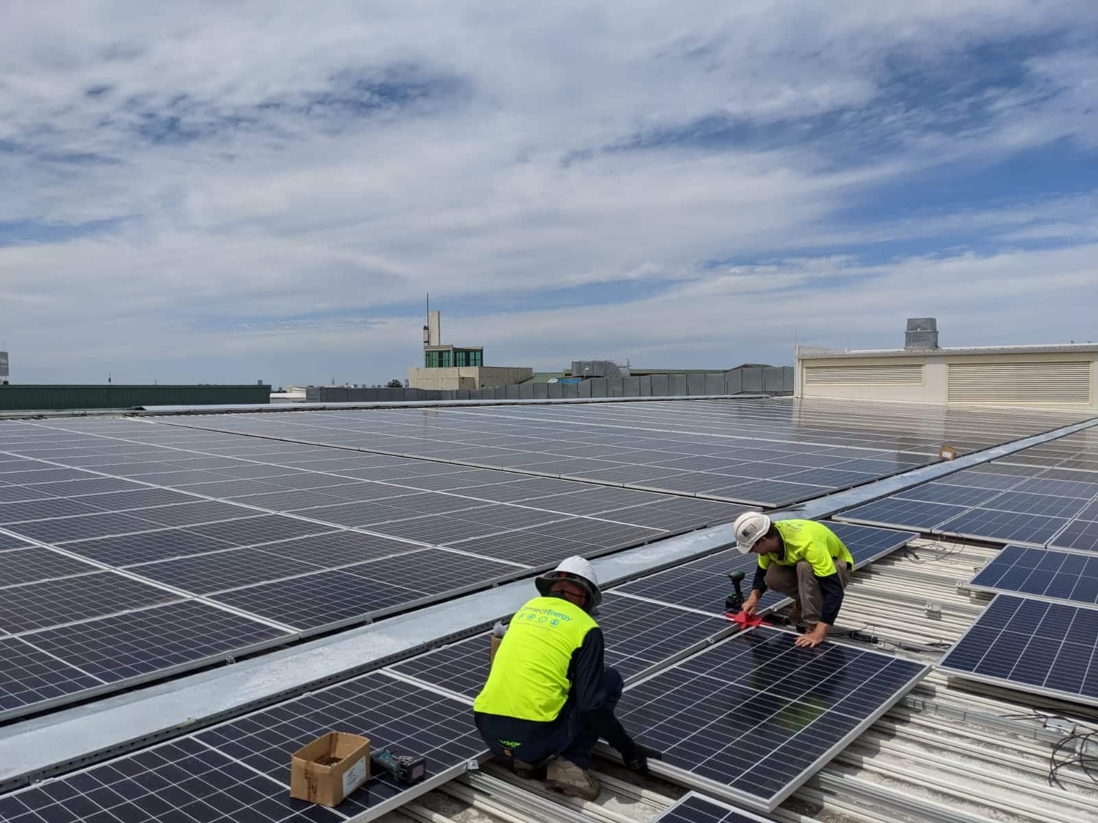 Technicians performing solar system maintenance and diagnostics on a commercial rooftop.